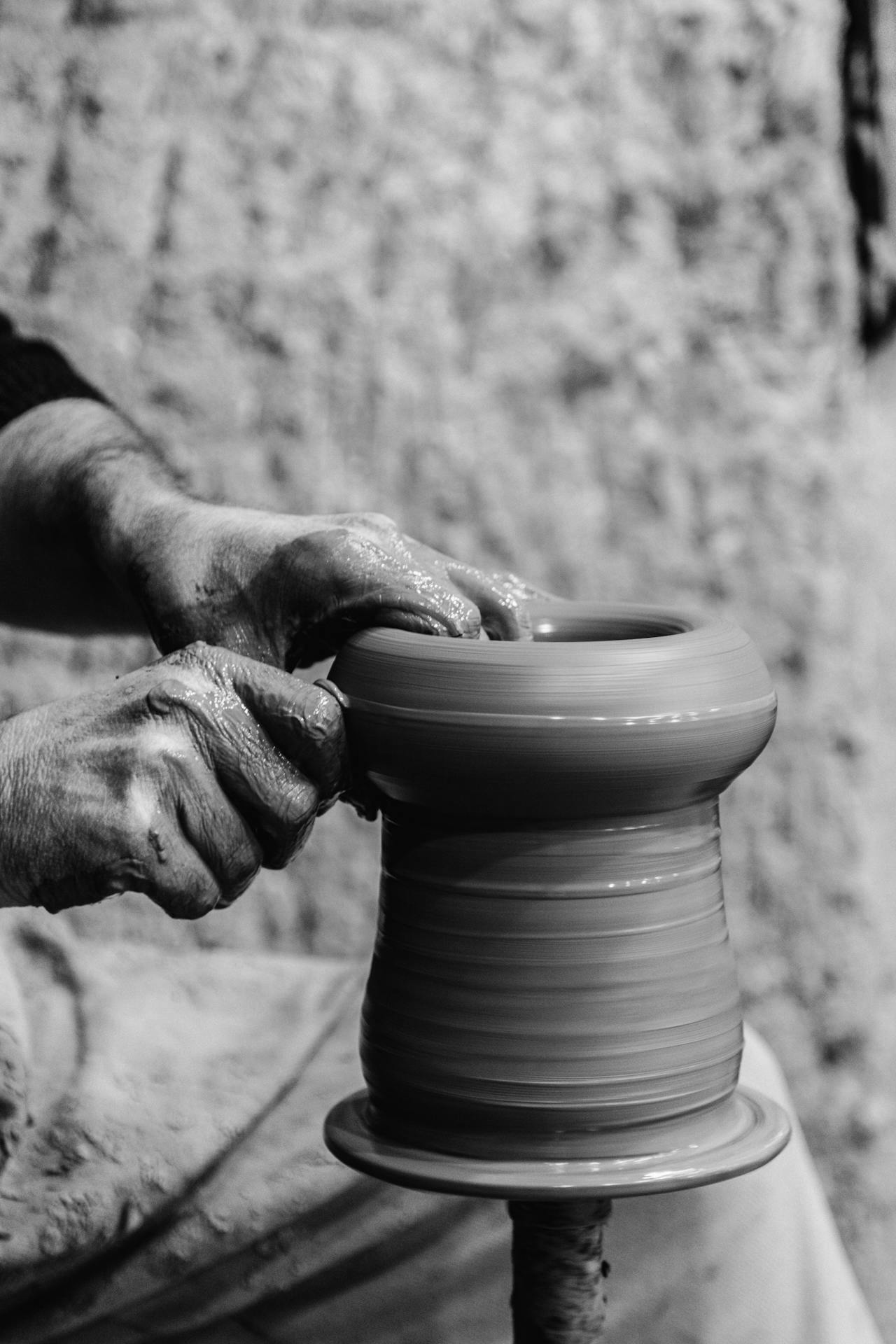 A potter shaping clay on a wheel